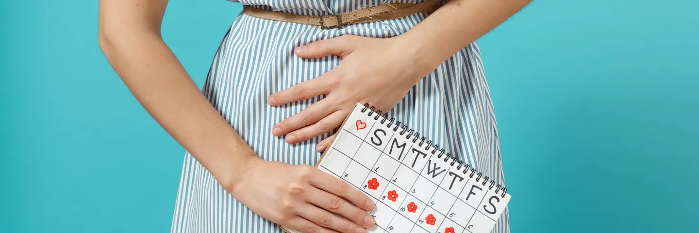 Žena drží menstruační kalendář