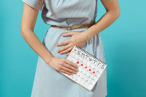 Žena drží menstruační kalendář